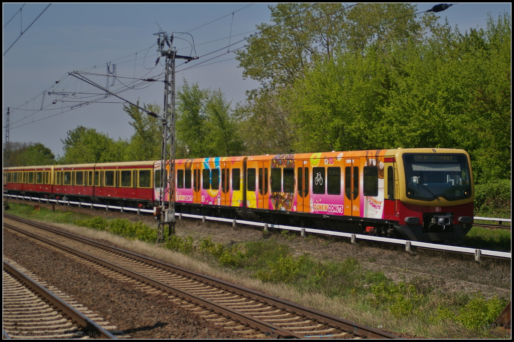 481 470 der S-Bahn Berlin mit der Seitenwerbung für  Dunkin Donuts  fährt als S75 Westkreuz gleich in den S-Bahnhof Berlin Hohenschönhausen ein.