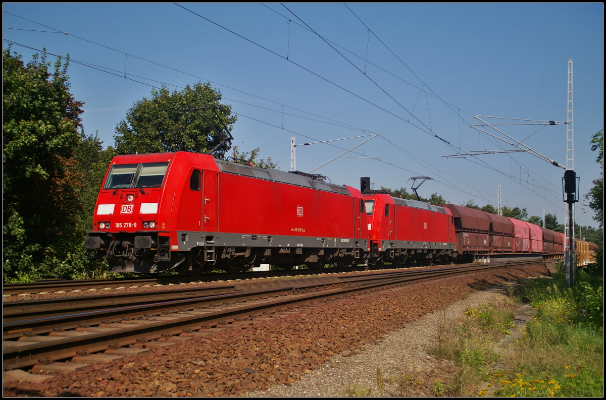 DB Cargo 185 278-9 und 185 394 fuhren mit dem Kohlependel am Vormittag des 30.08.2017 durch den Bahnübergang am S-Bahnhof Berlin Wuhlheide