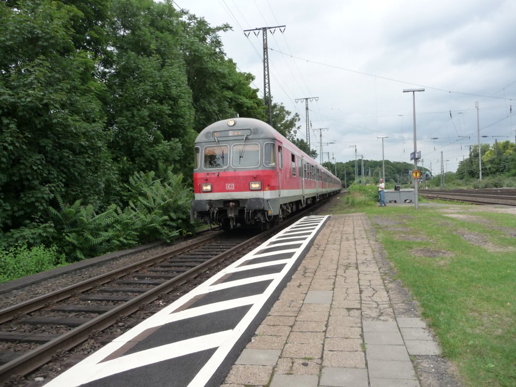 Eine n-Wagen-Garnitur mit einer Lok der Baureihe 218 am Zugschluss fhrt am 08.08.2012 in Kln-West ein.