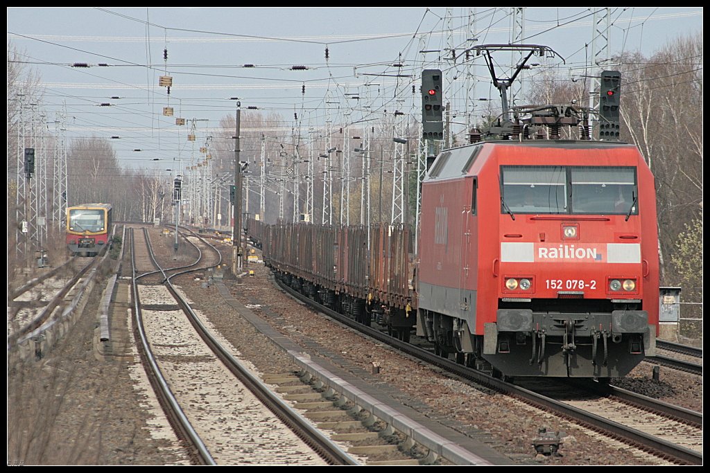 Railion 152 078-2 mit Rungenwagen berholt vor dem Bahnhof die NEB 27 (DB Schenker Rail Deutschland AG, Berlin Karow 30.03.2010)