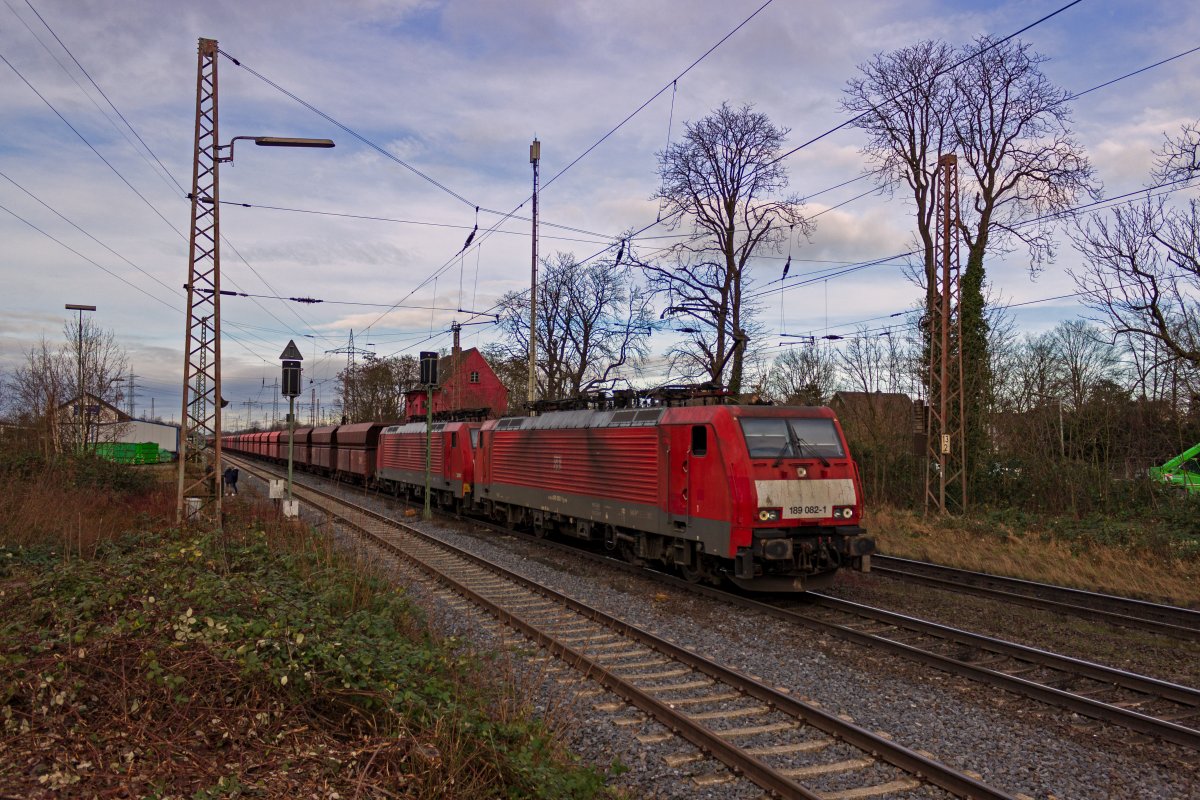 Am sdlichen Ende des Bahnhofes Lintorf hat dieser von 189 082 und 189 046 befrderte Erzzug soeben die Ausfahrsignale in Richtung Dsseldorf passiert. Der Zug ist aus sechsachsigen Falrrs-Wagen gebildet, die wegen der extrem hohen Zuggewichte ber Mittelpufferkupplungen verfgen. Interessanterweise hat die fhrende 189 082 jedoch keine solche Kupplung.