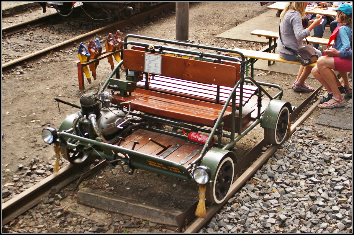 Die Motordraisine stammt aus dem Fuhrpark der MAV und kam dann in den Besitz eines Vereinsmitglieds der AG Märkische Kleinbahn e.V., der diese 2003 dem Verein schenkte. Ursprünglich besaß sie eine andere Lackierung und ein Windschild mit Spitzenlicht, das aber nicht Bautypisch war. So entschloss man sich die Draisine in den Urzustand zu versetzen. Als kleine Auffälligkeit zeigen sich die Reisigbesen vor jedem Rad um die Schiene zu säubern. Zu sehen war die Draisine am 10.09.2017 während des Tag der offenen Tür am 10.09.2017 in Berlin-Lichterfelde