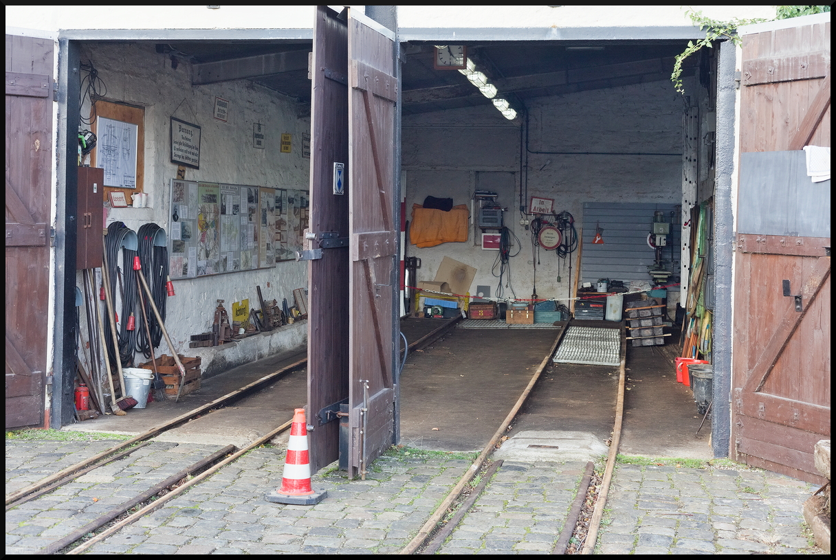 Blick in den kleinen zweiständigen Lokschuppen am Museumsbahnhof der Museumsfeldbahn Leipzig-Lindenau e.V.. Links an der Tafel hat der Verein eine kleine Dokumentation zur Feldbahn erstellt und konnte eingesehen werden. Der Blick entstand während des Besuchs am 29.12.2023 während der Glühweinfahrten.