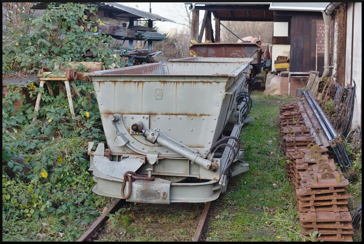 Neben dem kleinen Lokschuppen standen einige Loren verschiedener Bauart abgestellt, unter anderem diese Hydraulikkipper mit einem Fassungsvermögen von 3,3 m³. Gebaut wurden sie ca. 1951 von R. Dolberg AG Dortmund und waren beim Kraftwerk Neuötting zum Abtransport von Treibgut im Einsatz. Im Jahr 2013 kamen die beiden Loren dann zur Museumsfeldbahn Leipzig-Lindenau. Bei den Glühweinfahrten am 29.12.2023 habe ich die beiden Loren entdeckt.